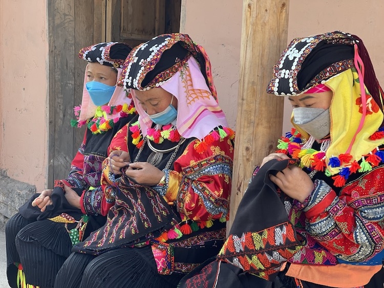 Phụ nữ thôn Lô Lô Chải (xã Lũng Cú, huyện Đồng Văn) ngồi thêu thổ cẩm bên hiên nhà