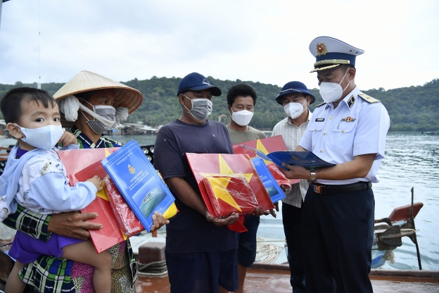 Lãnh đạo Bộ Tư lệnh Vùng 5 Hải quân và Đảng bộ Khối cơ sở Bộ Công Thương tại TP. Hồ Chí Minh tặng cờ Tổ quốc cho ngư dân