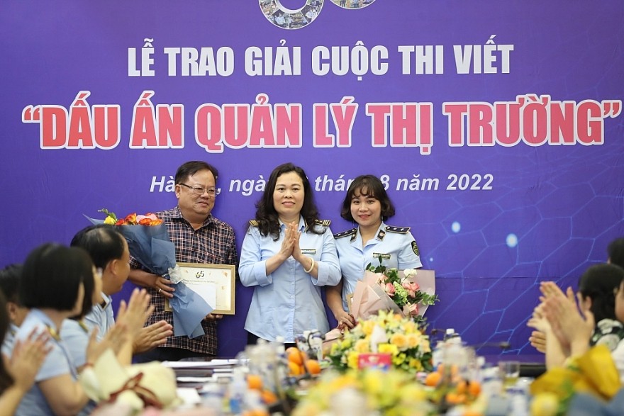 Đại diện Ban tổ chức - Phó Tổng cục trưởng Tổng cục QLTT Chu Thị Thu Hương trao hoa và Giấy chứng nhận cho các tác giả có tác phẩm đạt Giải B trong lực lượng QLTT