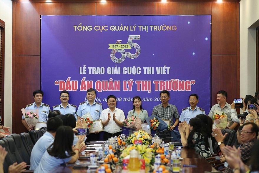 Đại diện Ban Giám khảo - ông Nguyễn Văn Minh trao hoa và Giấy chứng nhận cho các tác giả có tác phẩm đạt Giải Khuyến khích trong lực lượng QLTT